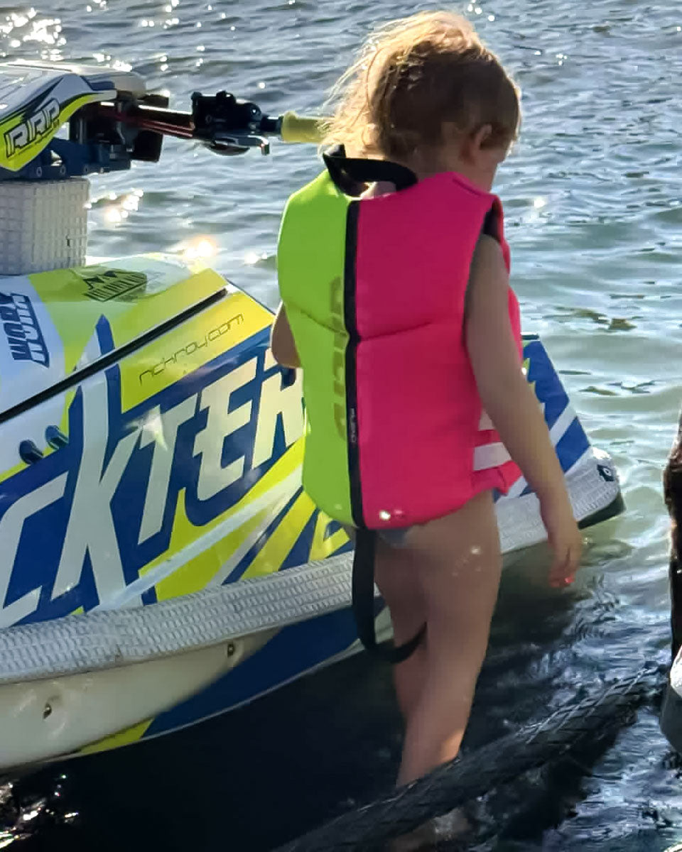 Child Neo Life Vest by Unlimited PWC with adjustable straps and bright safety color for secure flotation in water.
