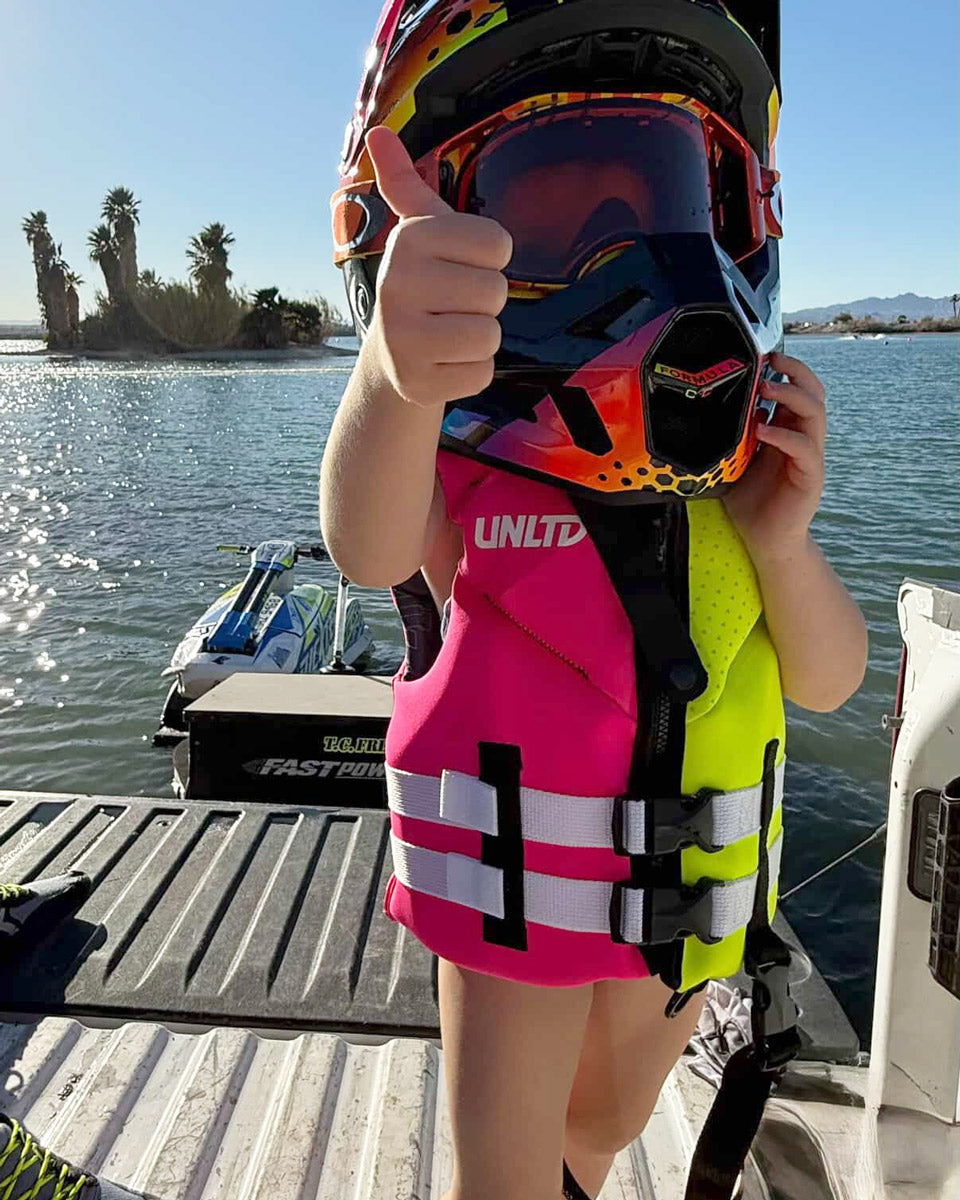 Child Neo Life Vest by Unlimited PWC, bright yellow and pink buoyancy vest with adjustable straps and front zipper for safety and comfort.