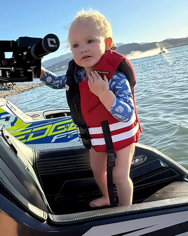 Child Neo Life Vest by Unlimited PWC featuring adjustable straps and bright red safety color, designed for water safety and buoyancy.