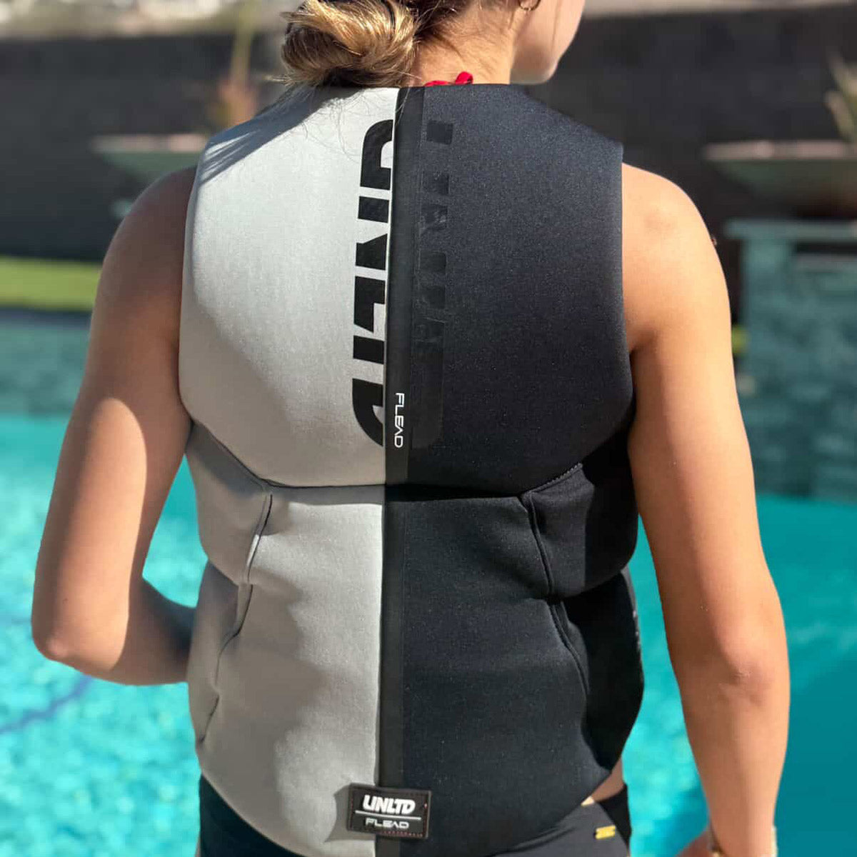UNLIMITED PWC FLEAD NEO VEST, a sleek black personal watercraft life vest with adjustable straps and reflective details.